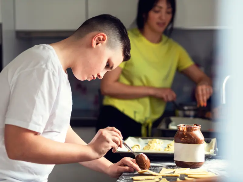Teenager learning to cook, an important life skill for independence in fostering.