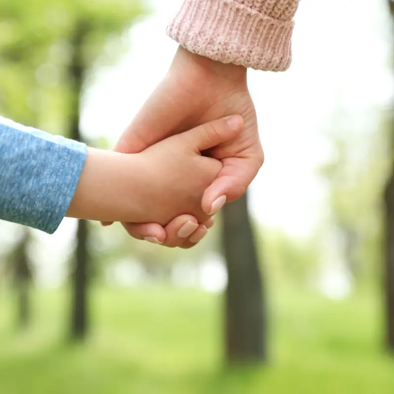 Foster Carer holding hands with a foster child